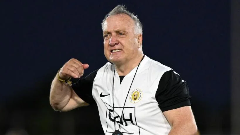 Dick Advocaat, wearing a white and black Curacao training top, gestures with his right arm